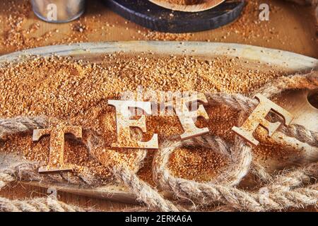 Teff, une alternative à l'ancien grain sans gluten avec le nom écrit en lettres de bois. Le téff est devenu un choix populaire pour une alimentation saine Banque D'Images