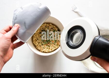 versez de l'eau bouillante et des nouilles instantanées Banque D'Images