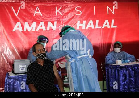 Yogyakarta, région spéciale de Yogyakarta, Indonésie. 1er mars 2021. Un commerçant du marché de Beringharjo, Yogyakarta, Indonésie, reçoit une vaccination Covid-19 d'un agent de santé, le lundi 1er mars 2021. La vaccination Covid-19 pour les commerçants, les travailleurs porteurs, les agents de stationnement, les gardes de sécurité et les vendeurs de rue dans la zone du marché de Beringharjo et Jalan Malioboro selon le président indonésien Joko Widodo totalisant 19,900. Il espère que cette vaccination sera bientôt terminée afin que le tourisme à Yogyakarta puisse se rétablir. Credit: Slamet Riyadi/ZUMA Wire/Alamy Live News Banque D'Images