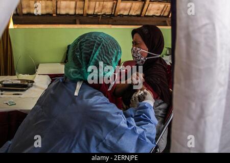 Yogyakarta, région spéciale de Yogyakarta, Indonésie. 1er mars 2021. Un commerçant du marché de Beringharjo, Yogyakarta, Indonésie, reçoit une vaccination Covid-19 d'un agent de santé, le lundi 1er mars 2021. La vaccination Covid-19 pour les commerçants, les travailleurs porteurs, les agents de stationnement, les gardes de sécurité et les vendeurs de rue dans la zone du marché de Beringharjo et Jalan Malioboro selon le président indonésien Joko Widodo totalisant 19,900. Il espère que cette vaccination sera bientôt terminée afin que le tourisme à Yogyakarta puisse se rétablir. Credit: Slamet Riyadi/ZUMA Wire/Alamy Live News Banque D'Images