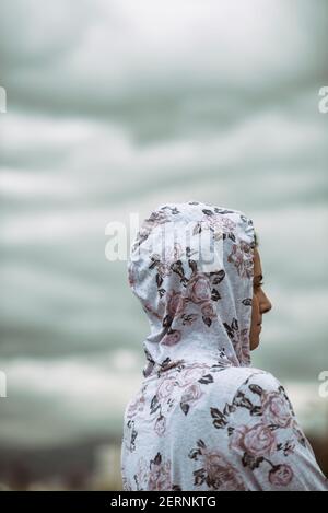 Jeune femme portant un sweat à capuche fleuri qui regarde loin de l'extérieur Banque D'Images