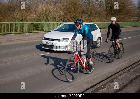 Dépassement de voiture deux cyclistes ; dépassement d'un cycliste, dépassement de véhicule, dépassement de véhicules lents, règle 188 du Code de la route pour le dépassement des cyclistes sur les routes du Royaume-Uni. Banque D'Images