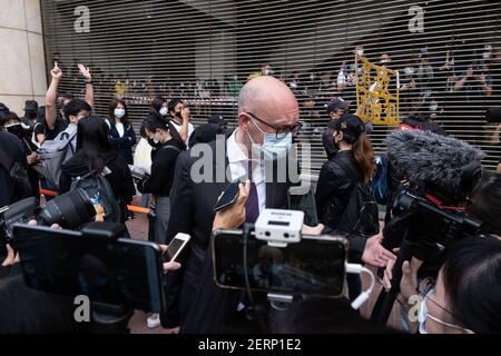 Charles Whiteley (C), Directeur adjoint du Bureau de l'UE, s'adresse aux journalistes lorsqu'il s'aligne devant la Cour de Kowloon Ouest. 47 militants pro-démocratie de Hong Kong accusés de conspiration pour renverser le pouvoir de l'État en vertu de la loi sur la sécurité nationale assistent à leur première audience judiciaire alors que des milliers de partisans se rassemblent devant le tribunal pour exprimer leur solidarité. Banque D'Images