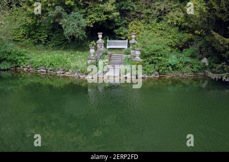 Un banc de jardin donnant sur le grand étang de Bonchurch sur l'île de Wight. L'étang et ses jardins ont été donnés au public par l'auteur Henry d Banque D'Images