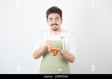 Prise de cuisinier mâle tenant une tranche de pizza sur blanc arrière-plan Banque D'Images