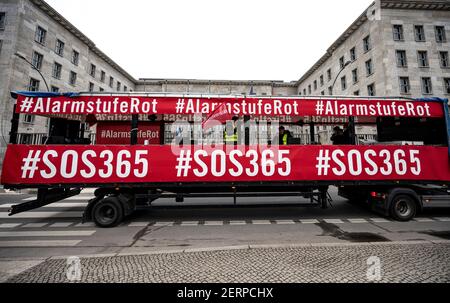 Berlin, Allemagne. 28 février 2021. Un camion avec des bannières indiquant « alarme niveau Rouge » et « #SOS365 » passe devant le ministère fédéral des Finances lors de la démonstration de voitures de l'industrie de l'événement. Credit: Fabian Sommer/dpa/Alay Live News Banque D'Images