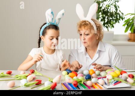 Concept de Pâques. La grand-mère avec sa petite-fille tient des œufs de Pâques à la maison Banque D'Images