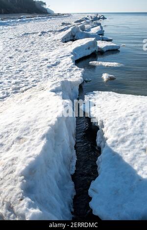 Paysage de bord de mer en hiver, glace et neige fonce sur la plage. Banque D'Images