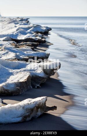 Paysage de bord de mer en hiver, glace et neige fonce sur la plage. Banque D'Images