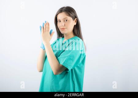 Femme médecin en gants médicaux montrant les mains sur fond blanc Banque D'Images