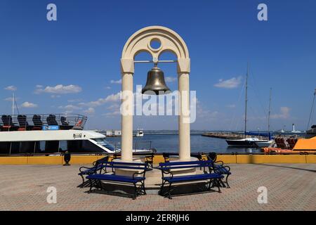 Cloche de bronze dans les rayons du soleil couchant contre un ciel nuageux dans le port de la ville d'Odessa , Ukraine 10 08 2020 Banque D'Images
