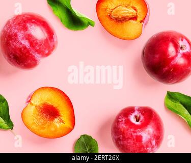 Carte de vœux et création de fruit rouge prune sur fond rose. Alimentation saine et diète concept d'alimentation. Composition de fruits frais d'été et arra Banque D'Images