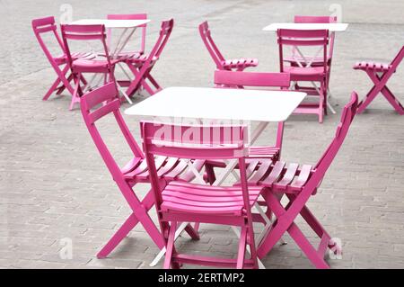 De jolies tables blanches et des chaises roses dans un café Une rue dans une ville d'Europe Banque D'Images