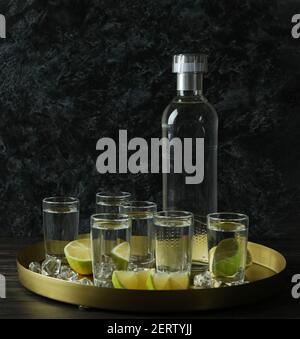 Plateau avec des doses et une bouteille de vodka sur une table en bois Banque D'Images