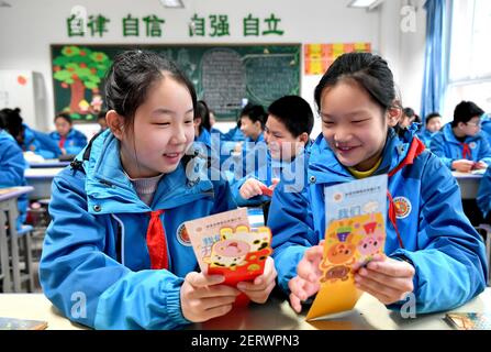 (210301) -- XI'AN, 1er mars 2021 (Xinhua) -- les élèves présentent des cartes de souhaits qu'ils ont reçues à l'école primaire expérimentale du district de Beilin, dans la province de Shaanxi, dans le nord-ouest de la Chine, le 1er mars 2021. Lundi marque le premier jour d'un nouveau semestre des écoles secondaires et primaires à Xi'an. Les élèves de l'école primaire expérimentale du district de Beilin ont été accueillis par des cartes de souhaits spéciales de leurs enseignants, les promettant de réaliser l'un de leurs souhaits au cours du nouveau semestre, y compris élever le drapeau national, déjeuner avec le directeur, embrasser un professeur favori, sauter à la maison Banque D'Images