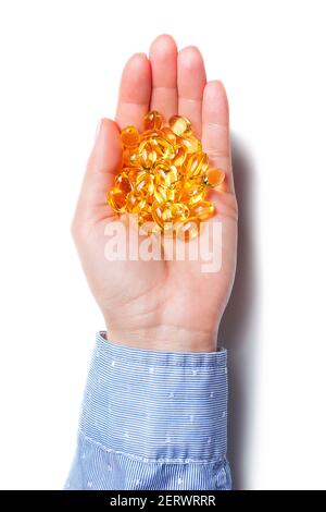Main tient les capsules omega-3 isolées sur fond blanc. Comprimés d'huile de poisson sur la paume Banque D'Images