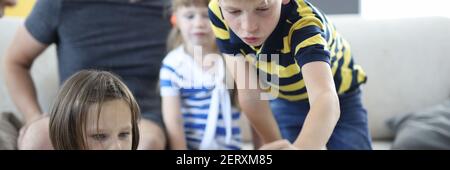 Un homme avec des enfants joue à des jeux de société à la maison. Banque D'Images
