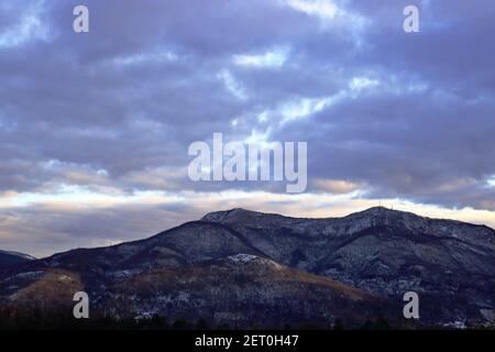 Vue sur les collines de Lombardie Italie après une chute de neige avec ciel nuageux. Banque D'Images