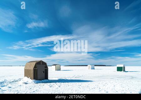 Pêche sur glace dans un port gelé le long de la côte de l'Île-du-Prince-Édouard, Canada. Banque D'Images