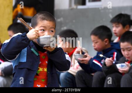 (210301) -- ZHENGHE, 1er mars 2021 (Xinhua) -- les élèves ont le petit déjeuner à l'école primaire du groupe ethnique Xijin She, dans le comté de Zhenghe, dans la province de Fujian, dans le sud-est de la Chine, le 1er mars 2021. Un nouveau semestre a débuté lundi à l'école primaire du groupe ethnique Xijin She. Seule école d'internat pour les élèves du primaire au niveau du village dans le comté de Zhenghe, c'est une « maison loin de chez soi » pour ses 167 élèves, dont près de la moitié sont des enfants laissés pour compte.l'école a grandi d'une école ordinaire établie en 1979, et a développé sa capacité d'embarquement grâce à un processus de reconstruction progressive grâce au fonds Banque D'Images