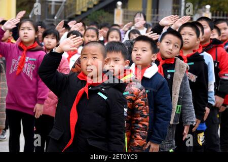 (210301) -- ZHENGHE, 1er mars 2021 (Xinhua) -- les élèves saluent le drapeau national lors de la cérémonie d'ouverture d'un nouveau semestre à l'école primaire du groupe ethnique Xijin She, dans le comté de Zhenghe, dans la province de Fujian, au sud-est de la Chine, le 1er mars 2021. Un nouveau semestre a débuté lundi à l'école primaire du groupe ethnique Xijin She. Seule école d'internat pour les élèves du primaire au niveau du village dans le comté de Zhenghe, c'est une « maison loin de chez soi » pour ses 167 élèves, dont près de la moitié sont des enfants laissés pour compte. L'école a grandi d'une école ordinaire établie en 1979, et a développé sa capacité d'internat Banque D'Images