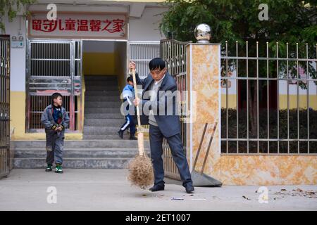 (210301) -- ZHENGHE, 1er mars 2021 (Xinhua) -- le chef Zhuang Guigan nettoie le campus de l'école primaire du groupe ethnique Xijin She dans le comté de Zhenghe, dans la province de Fujian, au sud-est de la Chine, 1er mars 2021. Un nouveau semestre a débuté lundi à l'école primaire du groupe ethnique Xijin She. Seule école d'internat pour les élèves du primaire au niveau du village dans le comté de Zhenghe, c'est une « maison loin de chez soi » pour ses 167 élèves, dont près de la moitié sont des enfants laissés pour compte.l'école a grandi d'une école ordinaire établie en 1979, et a développé sa capacité d'embarquement par un pro de reconstruction progressive Banque D'Images