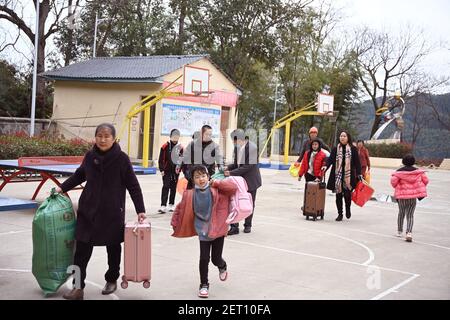 (210301) -- ZHENGHE, 1er mars 2021 (Xinhua) -- les gardiens envoient leurs enfants pour le nouveau semestre à l'école primaire du groupe ethnique Xijin She, dans le comté de Zhenghe, dans la province de Fujian, dans le sud-est de la Chine, 28 février 2021. Un nouveau semestre a débuté lundi à l'école primaire du groupe ethnique Xijin She. Seule école d'internat pour les élèves du primaire au niveau du village dans le comté de Zhenghe, c'est une « maison loin de chez soi » pour ses 167 élèves, dont près de la moitié sont des enfants laissés pour compte.l'école a grandi d'une école ordinaire établie en 1979, et a développé sa capacité d'embarquement par un rembuil progressif Banque D'Images