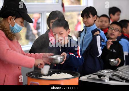 (210301) -- ZHENGHE, 1er mars 2021 (Xinhua) -- les élèves ont le petit déjeuner à l'école primaire du groupe ethnique Xijin She, dans le comté de Zhenghe, dans la province de Fujian, dans le sud-est de la Chine, le 1er mars 2021. Un nouveau semestre a débuté lundi à l'école primaire du groupe ethnique Xijin She. Seule école d'internat pour les élèves du primaire au niveau du village dans le comté de Zhenghe, c'est une « maison loin de chez soi » pour ses 167 élèves, dont près de la moitié sont des enfants laissés pour compte.l'école a grandi d'une école ordinaire établie en 1979, et a développé sa capacité d'embarquement grâce à un processus de reconstruction progressive grâce au fonds Banque D'Images