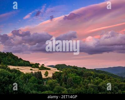 Des nuages magnifiquement colorés sur le paysage de montagne en début de soirée Banque D'Images