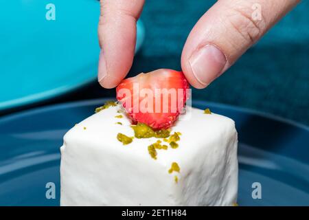 la main féminine décorera le gâteau. La main du chef pâtissier met des fraises fraîches sur le gâteau caillé Banque D'Images