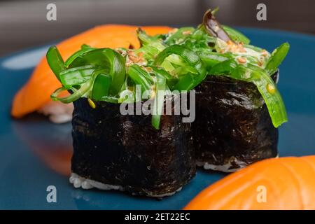 Chukka gunkan, sushi et petits pains sur une assiette bleue. Il sert de la cuisine japonaise Banque D'Images