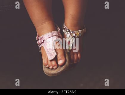 Gros plan des pieds d'une fille portant des sandales non assorties Banque D'Images