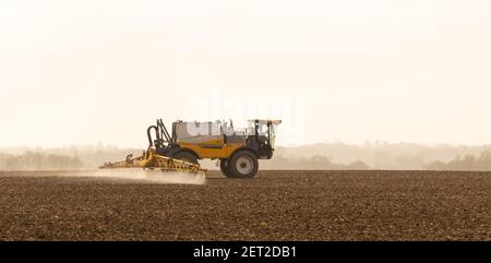 Agriculteur utilisant un pulvérisateur automoteur dans un champ au début du printemps. Mars 2021. Beaucoup Hadham, Hertfordshire. ROYAUME-UNI Banque D'Images