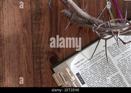 couronne d'épines et bible ouverte sur fond de bois sombre avec espace de copie Banque D'Images