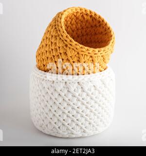 panier à la main jaune et blanc, sur fond blanc. texture de tresses en tissu tricoté Banque D'Images