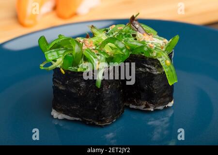 Deux petits pains à sushis Chukka gunkan sur une assiette bleue Banque D'Images