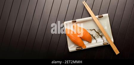 Sushi avec saumon sur une assiette avec baguettes. Vue de dessus. Banque D'Images