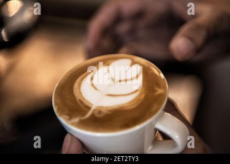 Gros plan d'une personne prête à servir un Latte piccolo Banque D'Images