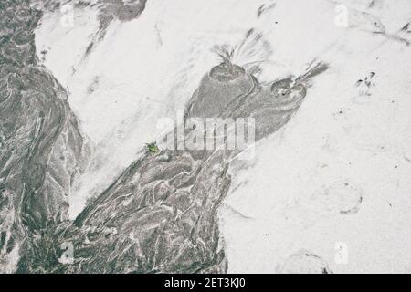 Beach Sand Owl, les eaux en cours de traitement laissent des motifs étranges dans le sable gris et les galets noirs. Celui-ci ressemble beaucoup à un hibou. Banque D'Images