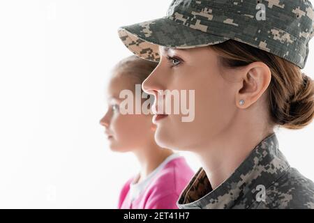 Vue latérale d'un soldat qui regarde loin près de sa fille sur image floue arrière-plan isolé sur blanc Banque D'Images