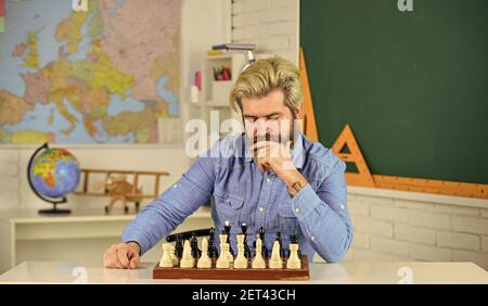 Figures sur le plateau d'échecs. Réfléchir à l'étape suivante. Faites votre propre pensée de manière indépendante. Leçon d'échecs. Concept de stratégie. Enseignant d'école. Jeu de société. Homme intelligent jouant aux échecs. Passe-temps intellectuel. Banque D'Images