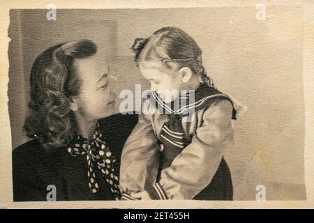 Allemagne - VERS les années 1940 : portrait de la mère et de la fille heureux assis en studio. Carte de vue d'époque Art déco Banque D'Images