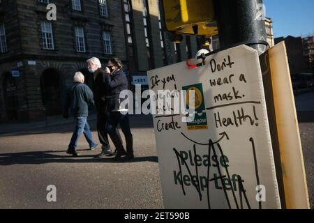 Glasgow, Royaume-Uni, le 1er mars 2021. Un panneau de sécurité avec anti-masque graffiti, dans les rues calmes du centre-ville, pendant le dernier verrouillage. Plus de 1.5 millions de personnes ont maintenant reçu leur première vaccination contre le coronavirus Covid-19 en Écosse. Crédit photo : Jeremy Sutton-Hibbert/Alay Live News. Banque D'Images