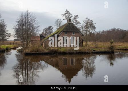 Vue sur la maison historique à la petite voie navigable dans reedland à Dwarsgracht, Weerribben, Overijssel, hollande Banque D'Images