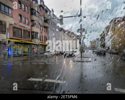 Rue de la ville européenne vue par la fenêtre couverte avec gouttes de pluie Banque D'Images