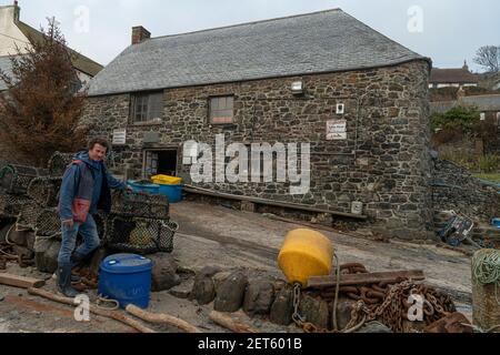 Cadgwith Cove, Cornwall, Royaume-Uni. 1er mars 2021. Les anciens bâtiments sont à Cadgwith Cove, utilisés par les pêcheurs qui atterrissent au port pour stocker leur matériel et traiter leurs prises. Ils abritent également une galerie d'art populaire et deux boutiques vendant du poisson frais, tandis qu'en été, les barbecues à poissons très populaires se tiennent à l'extérieur. Cadgwith Fishing Cove Trust tente de recueillir 300,000 000 livres pour acheter ces deux bâtiments afin de les protéger de tout développement futur. Credit: kathleen White/Alamy Live News Banque D'Images