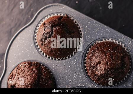 Muffins au chocolat tout juste cuits dans un plateau, concept de recette de cuisine de confort maison Banque D'Images