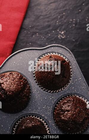 Muffins au chocolat tout juste cuits dans un plateau, concept de recette de cuisine de confort maison Banque D'Images