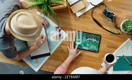 Vue de dessus de jeune couple avec tablette planification vacances vacances vacances, concept de voyage de bureau. Banque D'Images