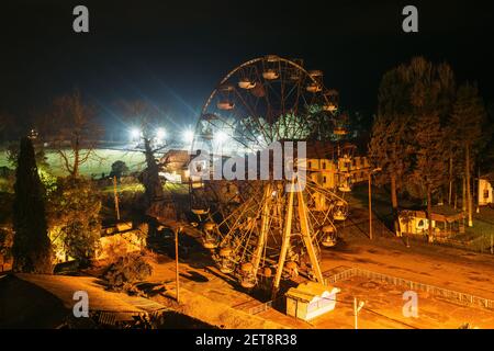 Vieux rouillé cassé abandonné Ferris roue la nuit. Banque D'Images